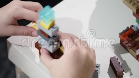 孩子们手拿着一块乐高积木玩双手合拢乐高是一种流行的建筑玩具视频的预览图
