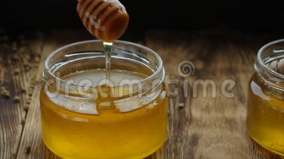 蜂蜜从蜂蜜勺子里滴出来一滴在黑色背景上关上视频的预览图