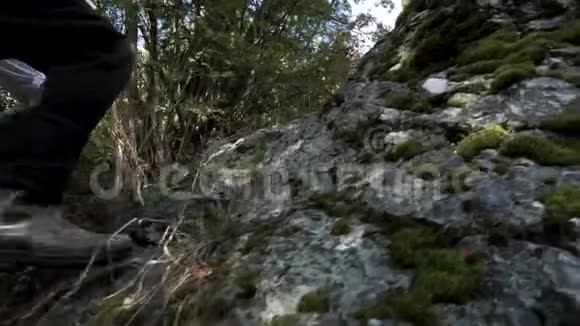 靠近登山者的双腿向山顶迈开脚步录像穿着橡胶靴和腿往上爬视频的预览图