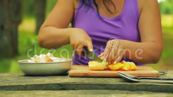 女人的手把橘子切成块做水果沙拉视频的预览图