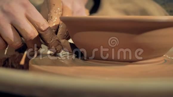 一个详细的观点陶工手切除了多余的粘土从碗视频的预览图