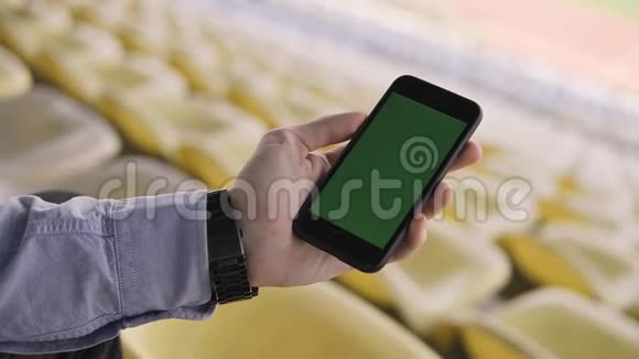 男人手里拿着一部户外绿色屏幕的智能手机视频的预览图