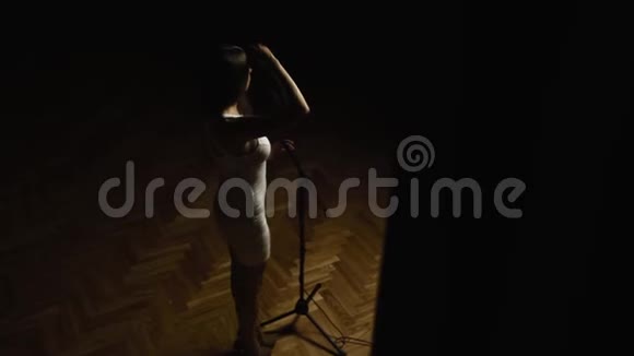 漂亮的女人长发穿着优雅的白色连衣裙站在舞台上与麦克风视频的预览图