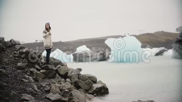 洛帕皮萨的年轻美女站在冰湖里游客独自探索冰岛的著名景观视频的预览图