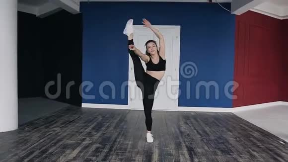 年轻漂亮的白种人女孩在大厅里练习跳舞背景是红蓝墙健身女孩训练视频的预览图
