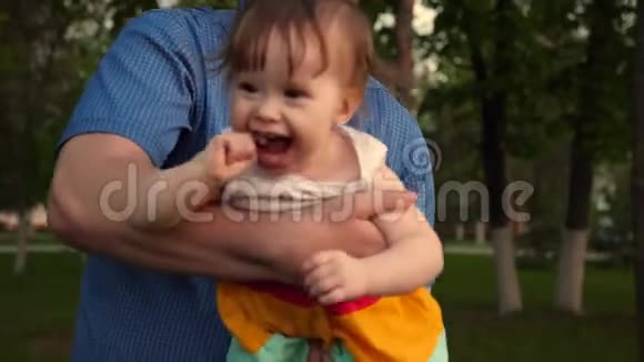 宝贝嘲笑爱父亲的手宝贝和爸爸笑着一起在公园散步视频的预览图