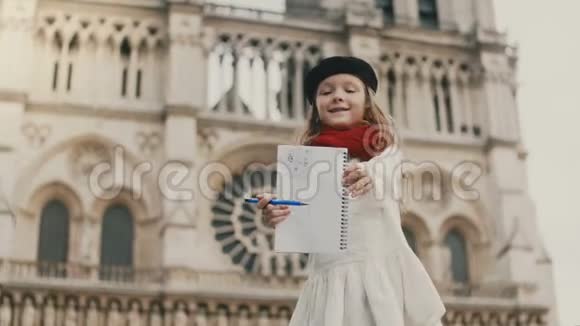 小美丽的女孩在镜头前展示她的照片微笑着法国巴黎圣母院附近的快乐孩子视频的预览图