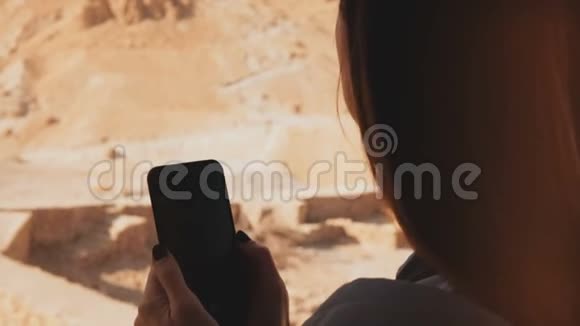 女孩在航空铁路客舱使用智能手机女人在阳光明媚的沙漠索道车上拍电话照片马萨达以色列4K视频的预览图