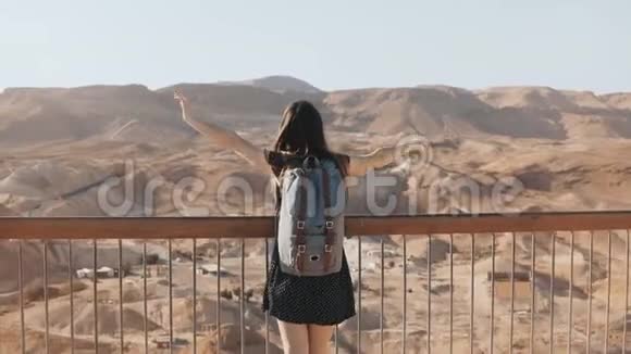 女孩站在巨大的山景双臂张开漂亮的欧洲女人快乐而兴奋自由马萨达以色列4K视频的预览图