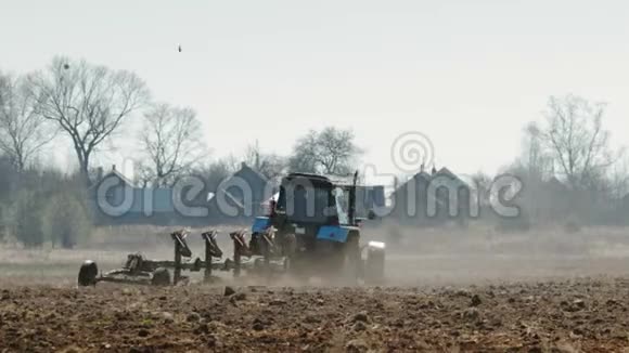 拖拉机蓝色的大黑色车轮和强大的轮沉重的犁黑暗肥沃的土壤温暖来自视频的预览图