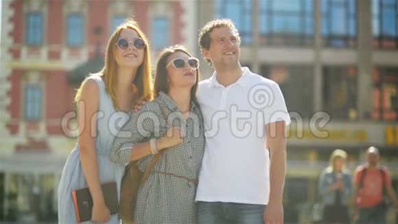 三个微笑的朋友一起在温暖的夏日户外度过时光穿白色衬衫的人站在视频的预览图
