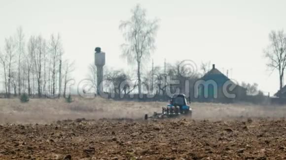 拖拉机蓝色的大黑色车轮和强大的轮沉重的犁黑暗肥沃的土壤农业视频的预览图