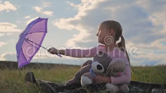 快乐有趣的小女孩带着雨伞和玩具孩子在户外玩大自然儿童梦概念视频的预览图