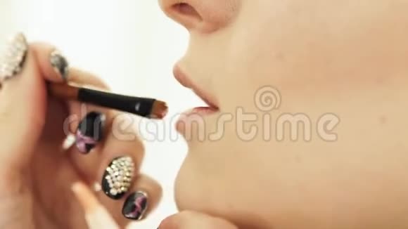 女性化妆师在唇妆上涂唇彩视频的预览图