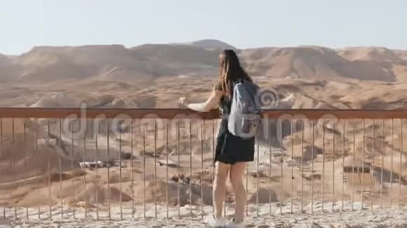 带背包的女人看着巨大的山景漂亮的白人女孩喜欢令人难以置信的沙漠全景以色列4K视频的预览图