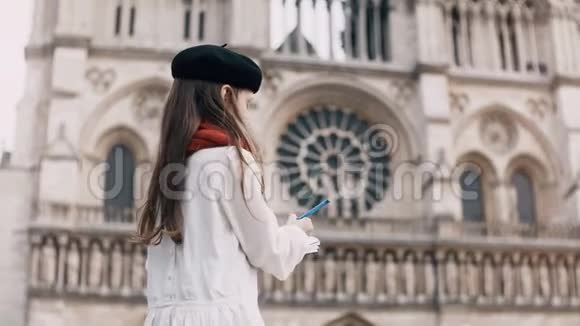 在法国巴黎圣母院附近著名的大教堂小艺术家穿着黑色贝雷帽和红领巾在笔记本上画画视频的预览图