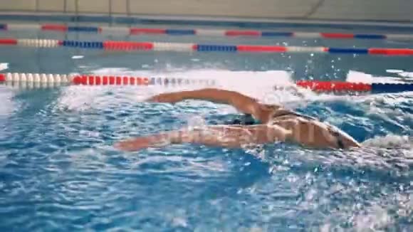 在蝶泳中强壮的游泳者以缓慢的动作手臂视频的预览图