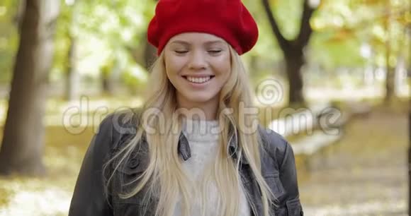 穿红色贝雷帽的女人在公园散步视频的预览图