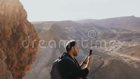 人类拍摄令人惊叹的沙漠景观欧洲男性游客在大山景中带相机以色列4K视频的预览图