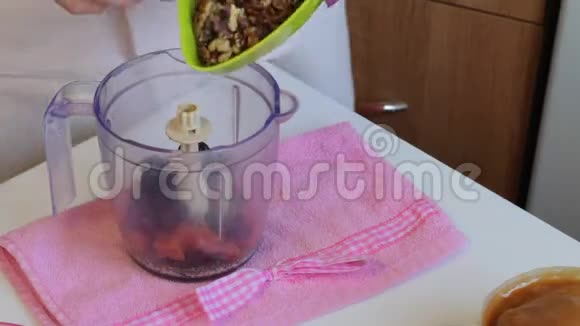 自制糖果放在盘子里旁边的食材为他们准备女人把坚果扔进搅拌机里视频的预览图