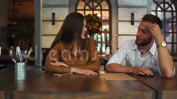 不错的一对夫妇坐在餐馆里她正喝着茶看着菜单而她的男朋友却在视频的预览图