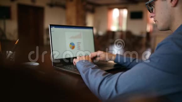 在咖啡馆里专心致志地在笔记本电脑上工作的自由主义者商人的后景人在电脑键盘上打字视频的预览图