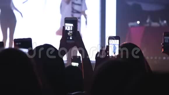 在音乐节上举起双手的观众剪影的人在人群中举手跳舞视频的预览图
