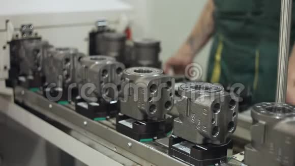 工厂工人控制输送线上的生产质量机器零件视频的预览图