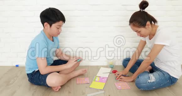 亚洲儿童学习与母亲一起折叠日本纸折纸视频的预览图