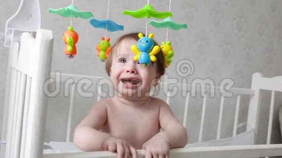 小宝宝站在婴儿床上哭拉着笔视频的预览图