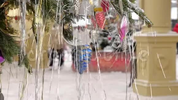 用球和玩具装饰的圣诞树她站在街上下雪了在背景中节日视频的预览图