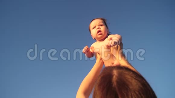 快乐的宝宝在蓝天上由妈妈手举动作缓慢视频的预览图