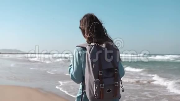 女孩走在夏天的海滨思考生活自由和撤退的概念风吹在头发上神奇的天空4K视频的预览图