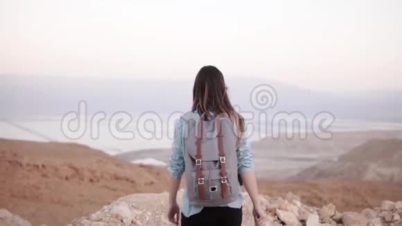 山顶上的女孩双臂张开慢动作漂亮的欧洲女旅行者很兴奋幸福以色列沙漠视频的预览图