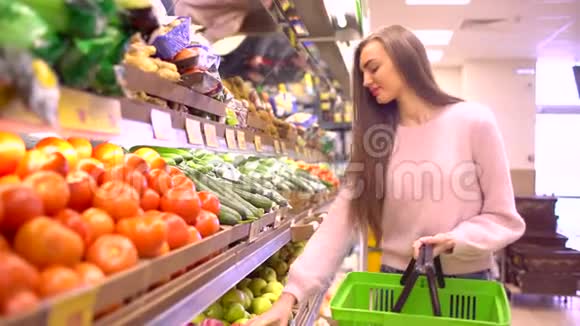 从超市水果摊上的盒子里拿绿色苹果的女人视频的预览图
