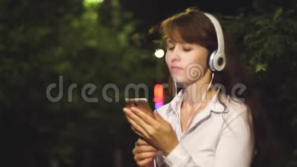 戴耳机的女孩包括歌曲触摸电话挥动长发跳舞微笑和Kayfuya从音乐在晚上视频的预览图