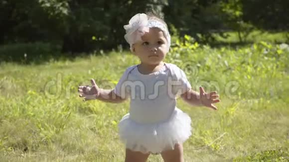 可爱的一岁小女孩走出户外的第一步孩子第一步的慢镜头视频的预览图