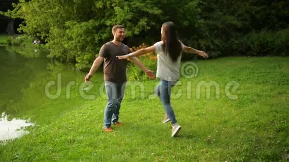 健康强壮的男朋友在市立公园拥抱并在户外旋转他的女朋友可爱的一对享受夏天视频的预览图