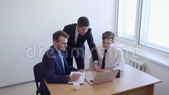 女人坐在办公桌前团队站在她身边视频的预览图