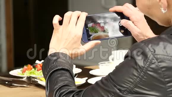 户外咖啡厅的女人拍了一张食物沙拉和一杯咖啡的照片慢动作视频的预览图