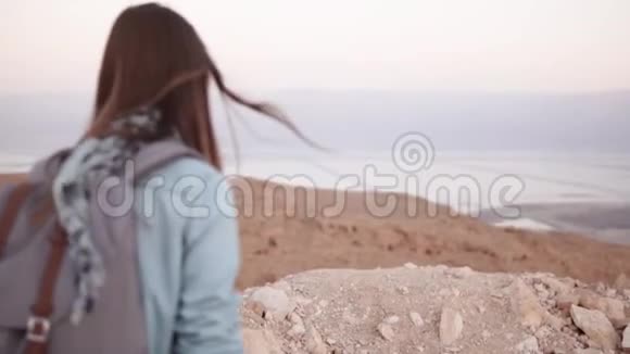 女人拍蒙丹风景的照片慢动作休闲旅行者女孩带背包使用智能手机以色列死海视频的预览图