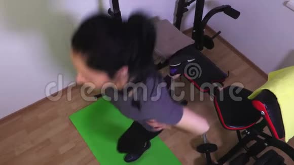 一条腿坐在健身房长椅上的女人视频的预览图