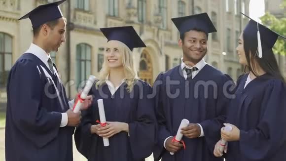 一群大学朋友在学术领域拥抱在一起毕业日视频的预览图