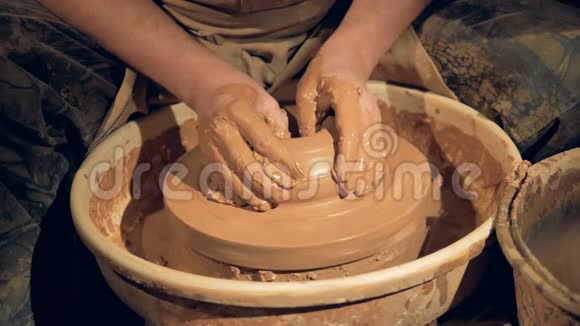 陶工的手在轮子上做一个宽而低的碗视频的预览图
