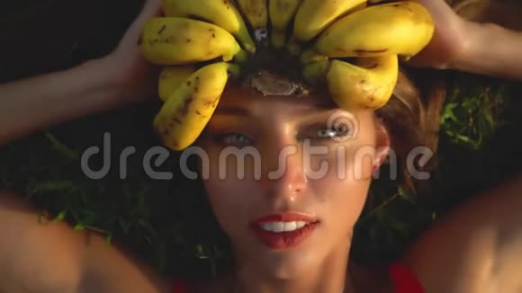 一个女孩长着香蕉模特儿躺在草地上头上挂着一串香蕉视频的预览图