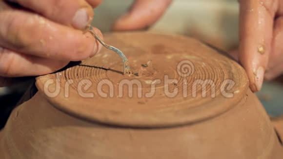 一个陶工在碗底表面切割他的签名的详细视图视频的预览图