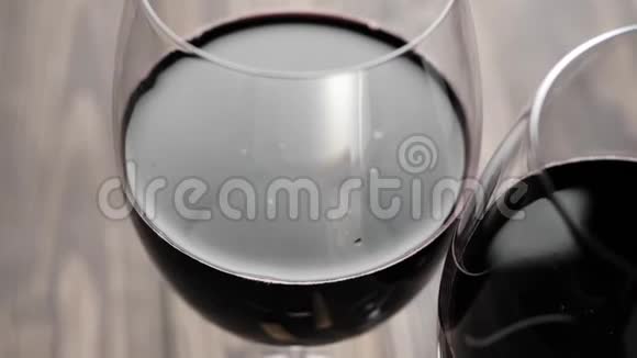 豪华红酒两杯红酒由桌子上的红葡萄在黑色背景下制成视频的预览图