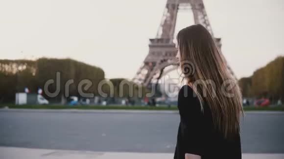 法国巴黎埃菲尔铁塔附近散步的快乐年轻女子看着摄像机微笑着对某人视频的预览图