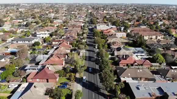 驾驶汽车沿郊区道路向周围行驶的空中无人机视频的预览图