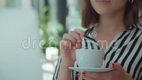 女人的肖像拿着一杯咖啡看录像视频的预览图